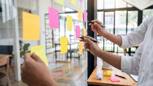 man organizing sticky notes on wall